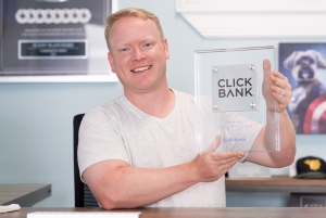 Robby Blanchard holding a ClickBank award